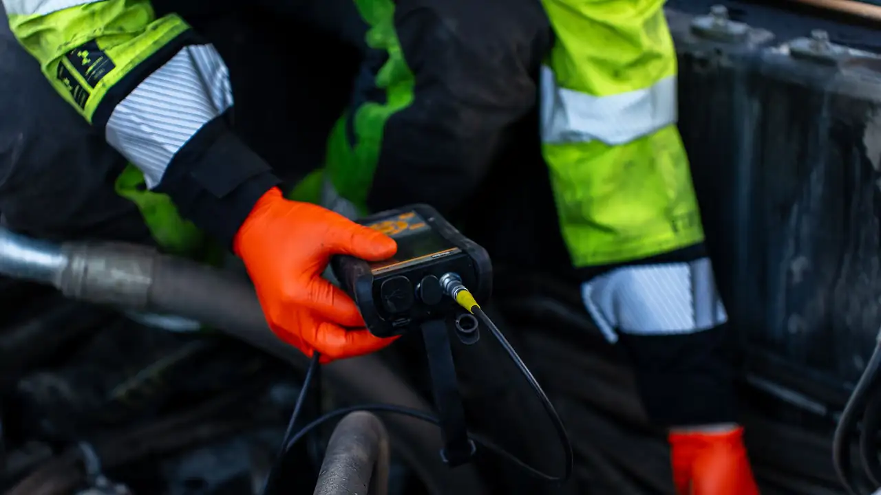 Tekniker med diagnoseverktøy kontrollerer maskin